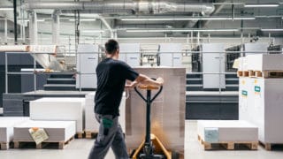 Lagerhalle Von Stern'sche Druckerei Mann mit Job bringt Papierrollen und verschiedene Papierformante