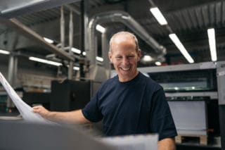 Mitarbeiter Mann lachend Testdruck Magazin Bogendruck Druckerei von Stern'sche    