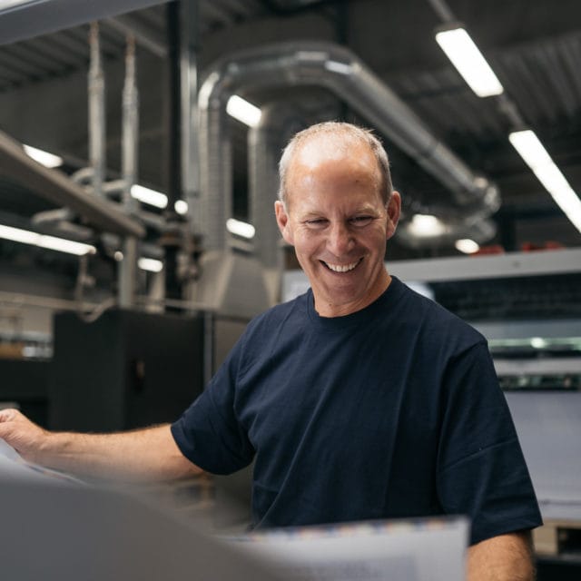 Mitarbeiter Mann lachend Testdruck Magazin Bogendruck Druckerei von Stern'sche