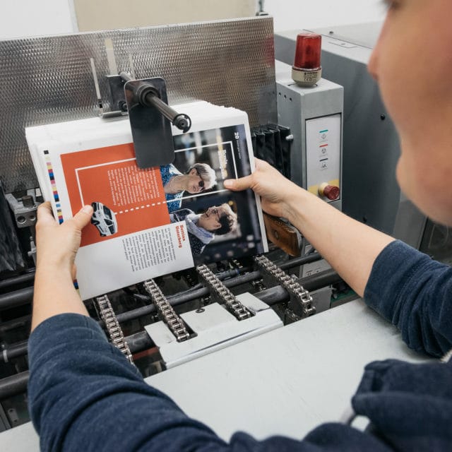 Weiterverarbeitung Mitarbeiterin bei der von Stern'sche Druckerei Lüneburg verarbeitet Broschüren individuell weiter